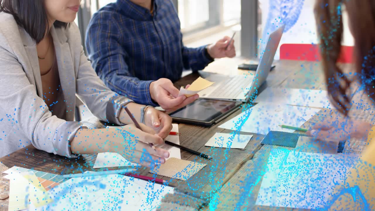 Design team arranging fabric swatches on wood table for materials while teal overlay marking colors