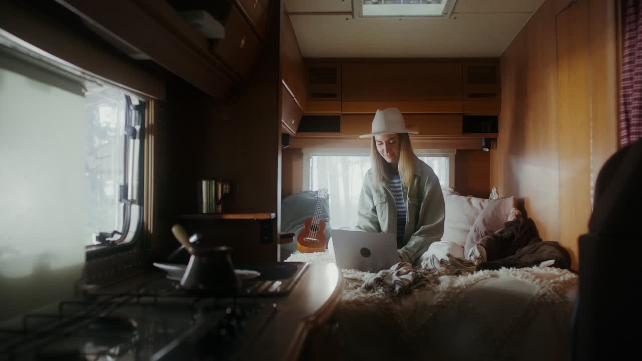 Donna che lavora al laptop in un accogliente camper