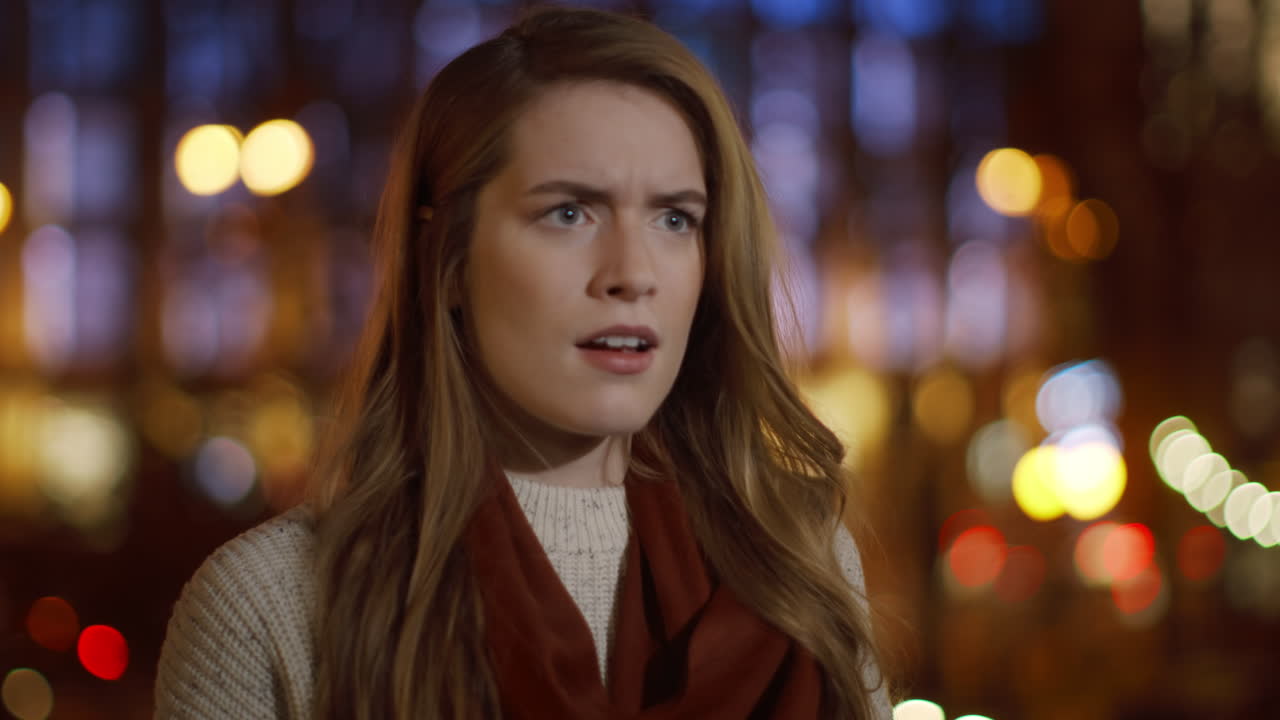 밖에서 휴대 전화 문자를 읽는 악한 여자. 화난 소녀가 전화 화면을 찾고