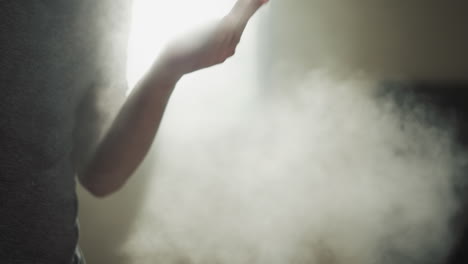 fighter uses talc powder to dry palms in gym closeup. young boxer prevents hand sweating with talcum in martial arts club slow motion. athletic products