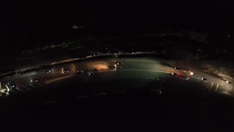 huge pack of bikers riding at night on a narrow road at night, aerial drone view