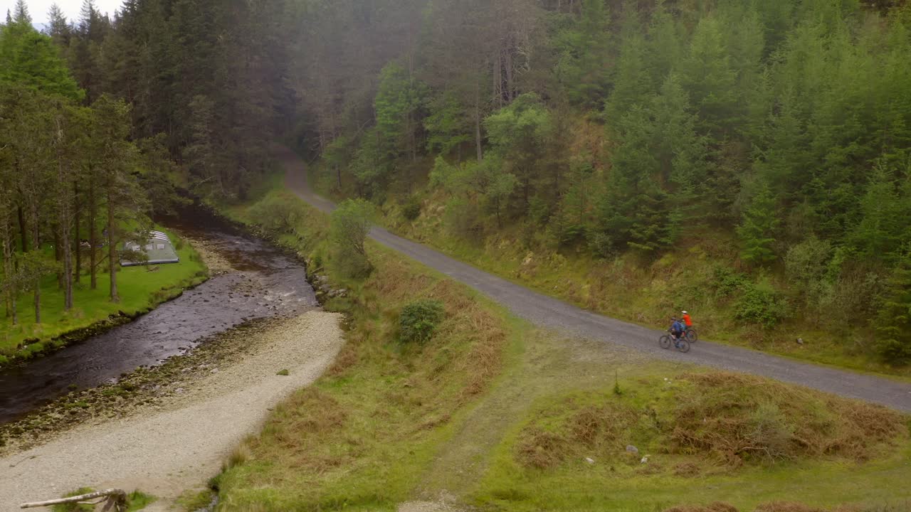 Babbling river flows smoothly as cyclist bike along trail in irish forest of Wild Nephin National Park