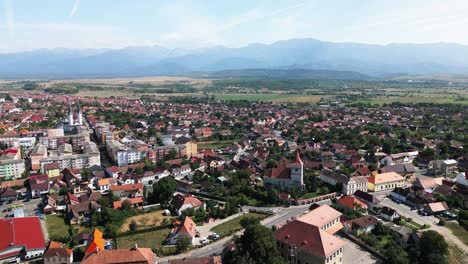 small romanian village with a blue sky and beautiful mountains in the background, carpathians, romania, europe, drone, summer