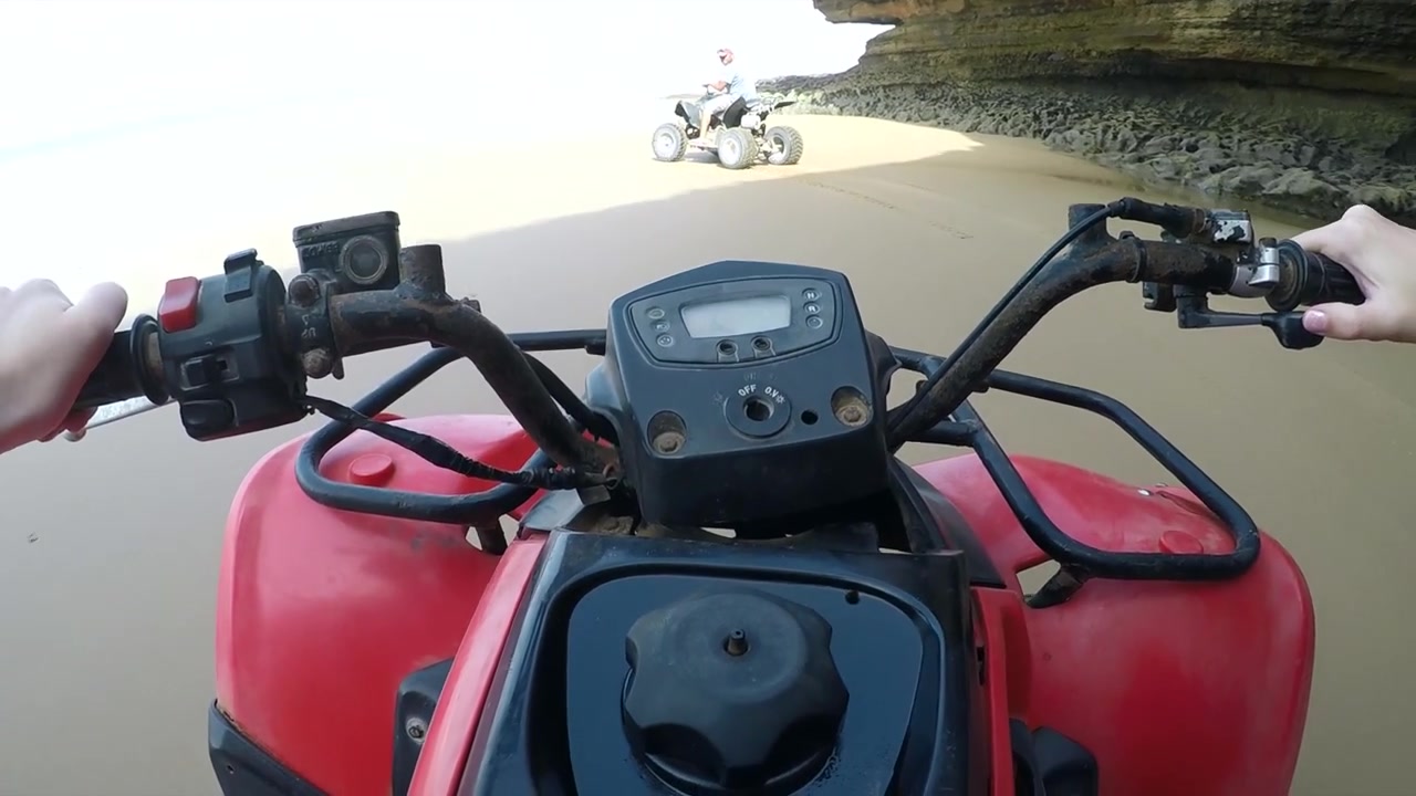 POV di due quad che sfrecciano sotto una grotta sulla spiaggia di Sidi Kaouki, Marocco.