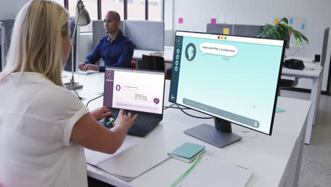 mujer caucásica en la oficina usando computadoras con mensajes digitales en las pantallas