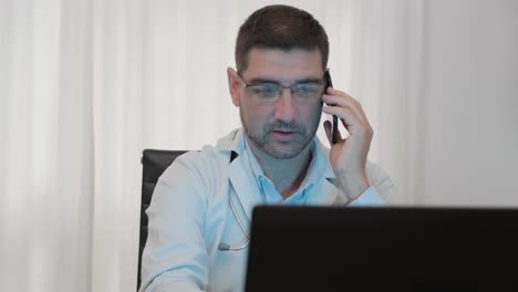 médico masculino de guardia mientras trabaja en una computadora portátil en el hospital