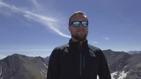 hiker standing on top of mountain close up, reflective sunglasses rockies kananaskis alberta canada