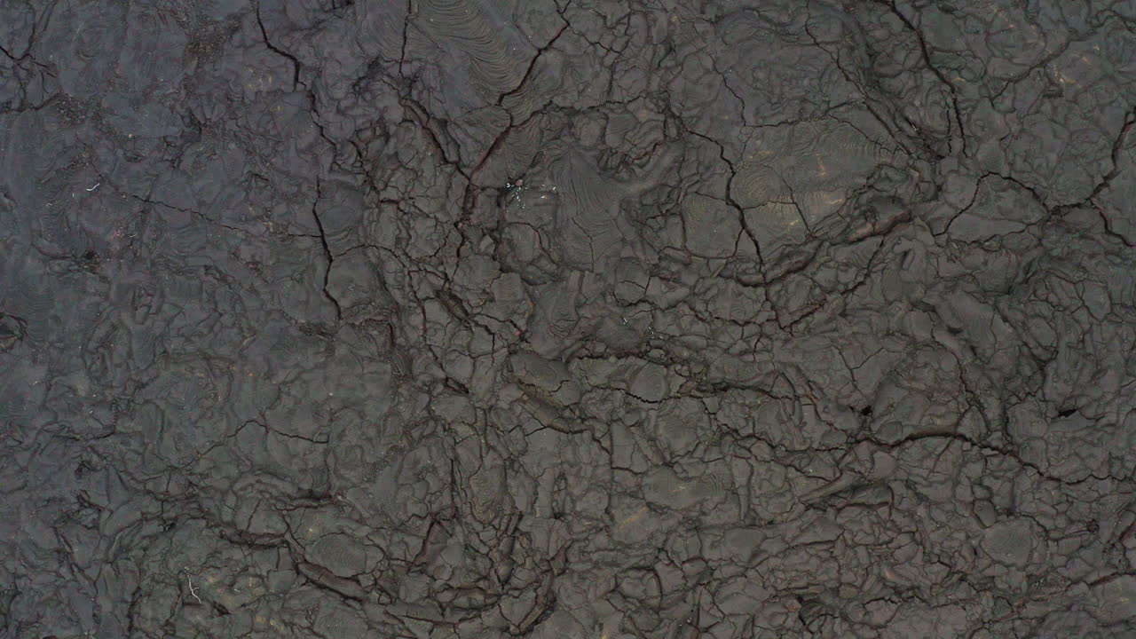 sobrevuelo de drones aéreos campos de lava de volcán estéril negro en hawaii, 4k