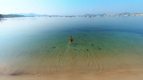 man entering the water of the port of pollenca