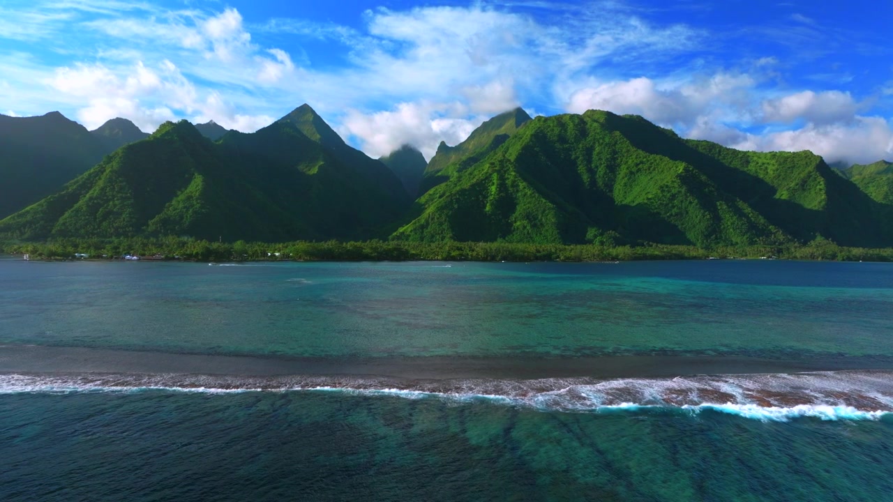 Teahupo'o surf waves crash on coral reef aerial drone Tahiti French Polynesia island sunny blue sky lagoon surfing Passe Havea harbor landscape lagoon The End of the Road village of town left motion