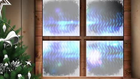 christmas tree and wooden window frame against light trails and spot of lights on blue background