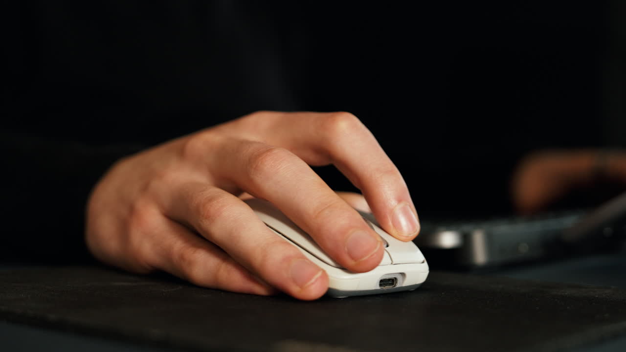Close-up shot of a person using a computer mouse while working. Subtle clicks, focused hand movement, and a clean desk setup create a productive, modern workspace vibe