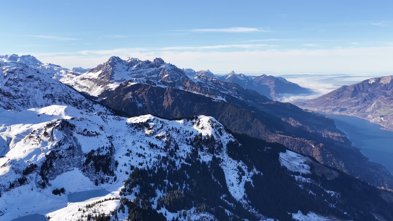 Aerial view of Walensee Lake surrounded by snowy Swiss Alps. Winter alpine landscape with mountains, water, and valleys, cinematic travel scenery, concept of freedom, adventure, and natural beauty