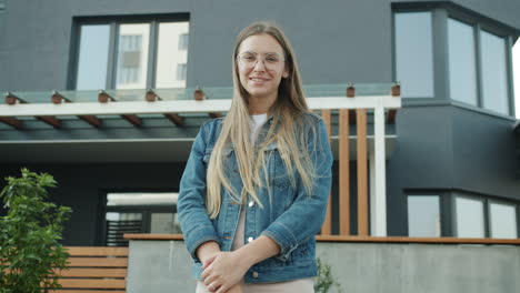 young woman in front of modern apartment building