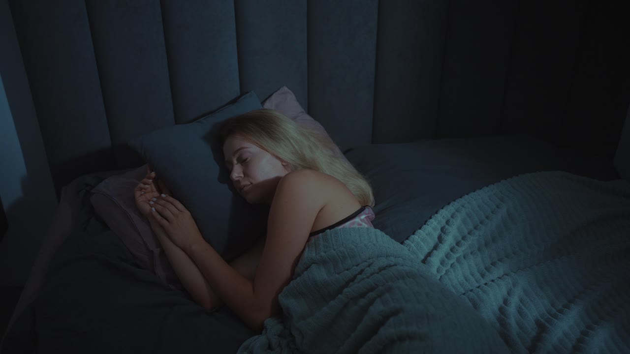 mujer durmiendo en la cama por la noche