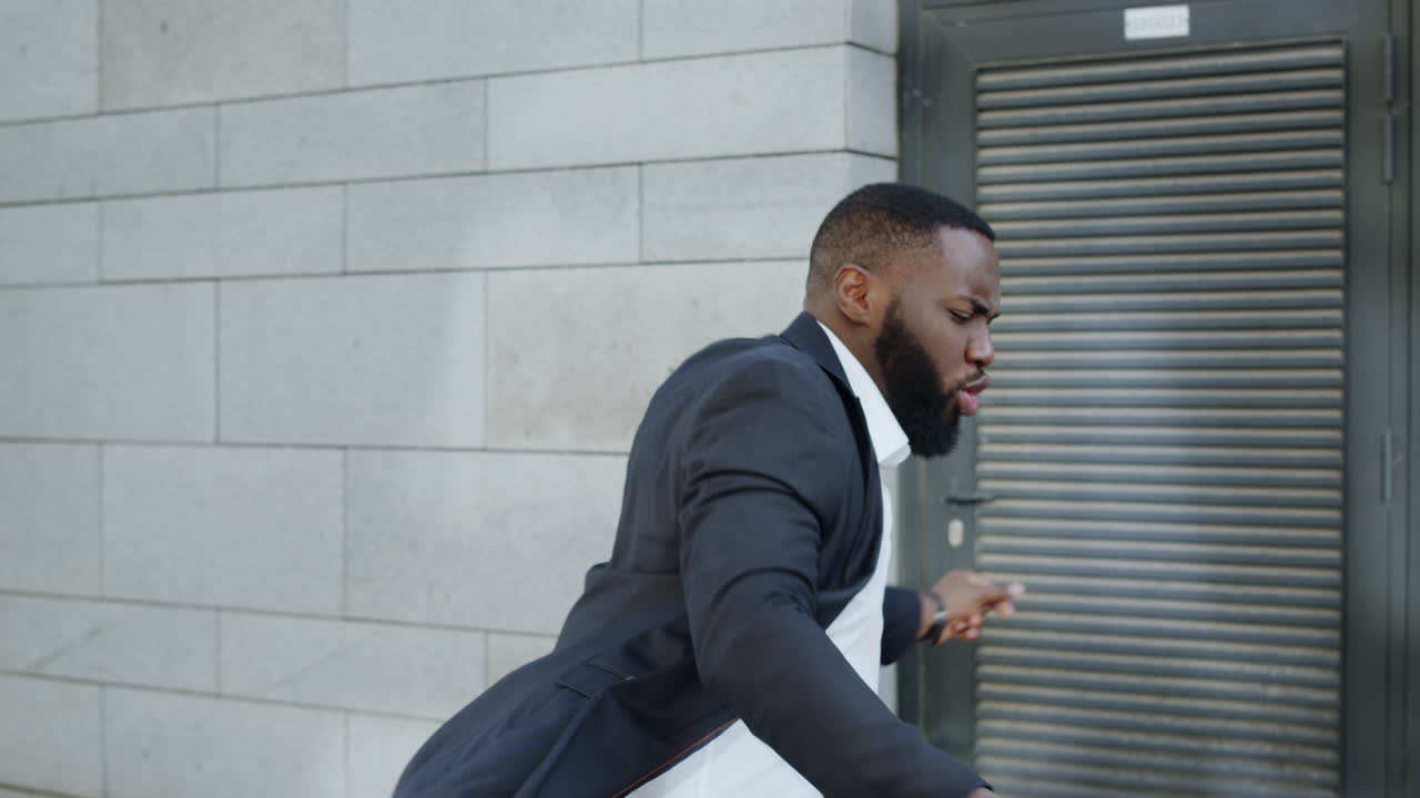 Businessman dancing on city street. African business man celebrating victory