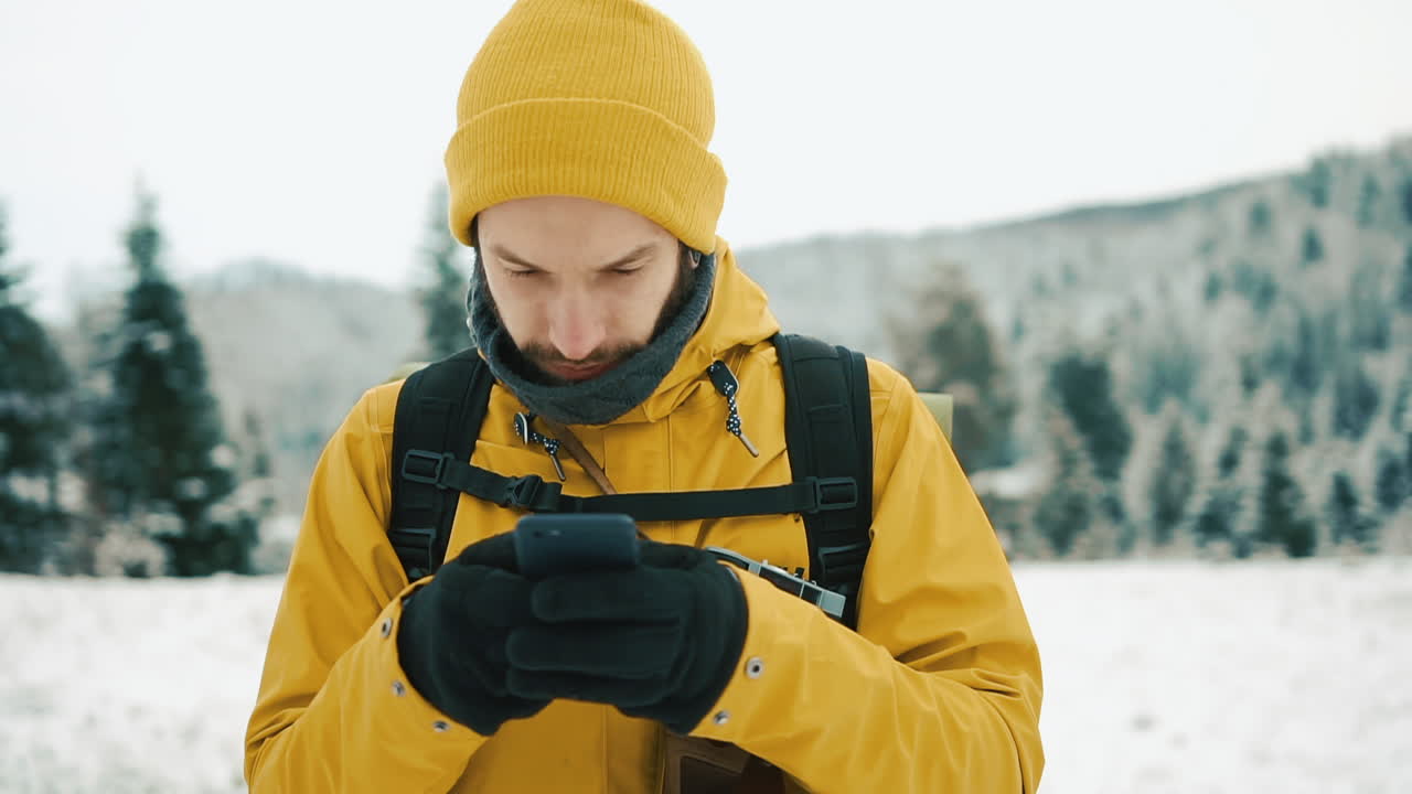 Man Texting in Winter Landscape