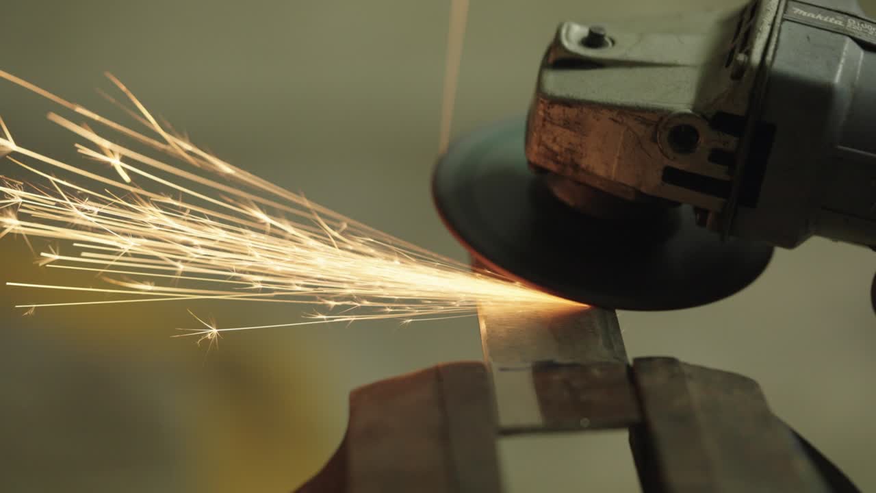 많은 불꽃을 일으키는 건설 각 밀러에서 작업자의 클로즈업