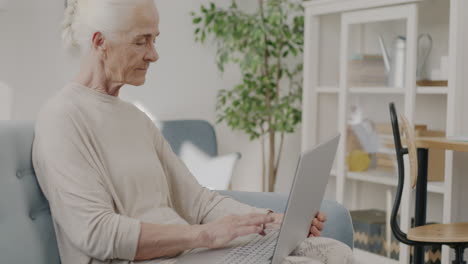 mujer mayor usando una computadora portátil en casa