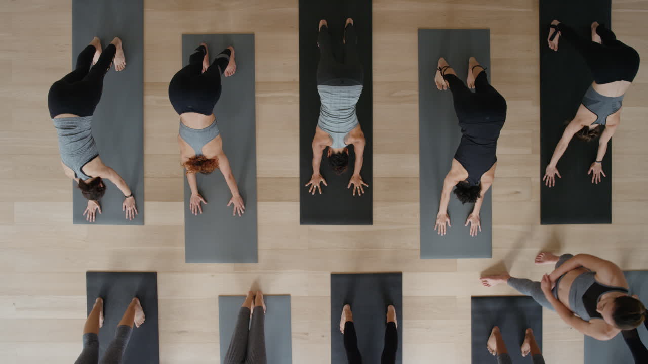 피트니스 스튜디오에서 건강한 생활방식을 즐기는 여성들에게 아래쪽을 향한 개 자세를 가르치는 최고의 요가 수업 강사