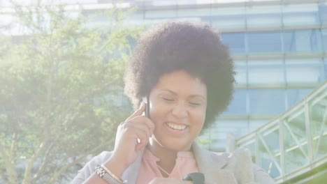 Happy-plus-size-biracial-woman-checking-smartwatch-and-walking-in-city