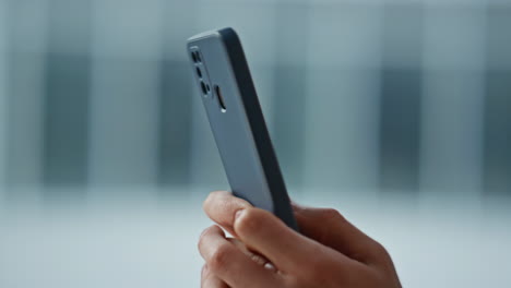 man fingers texting cellphone at home closeup. businessman typing on smartphone