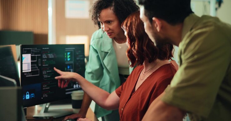 Diverse Team of Software Developers Collaborating on Code in Modern Office