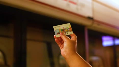 person displays card in front of train