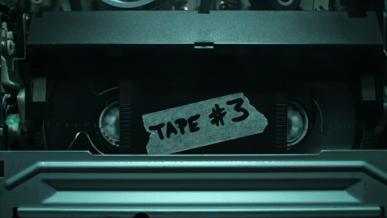 Inserting VHS Tape - Video Cassette Being Pushed into the VCR, the Tape Transport Mechanism in Macro - Smoky Interrogation Room