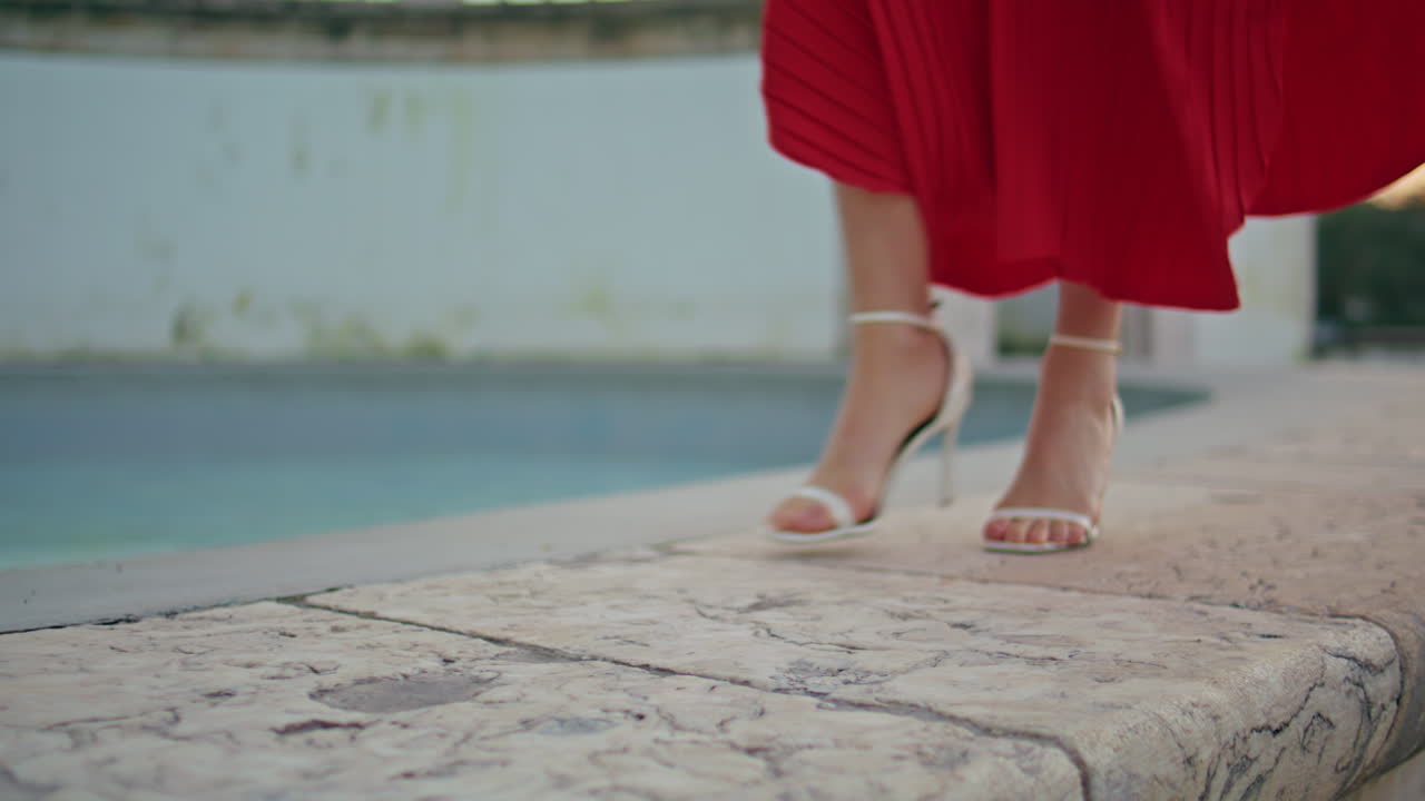 Woman feet walking fountain border at summer weekend closeup. Windy evening