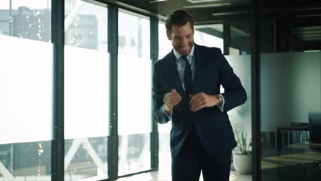 a well-dressed businessman is joyfully celebrating a significant accomplishment in a sleek office environment. bright sunlight floods through large windows, enhancing the atmosphere.