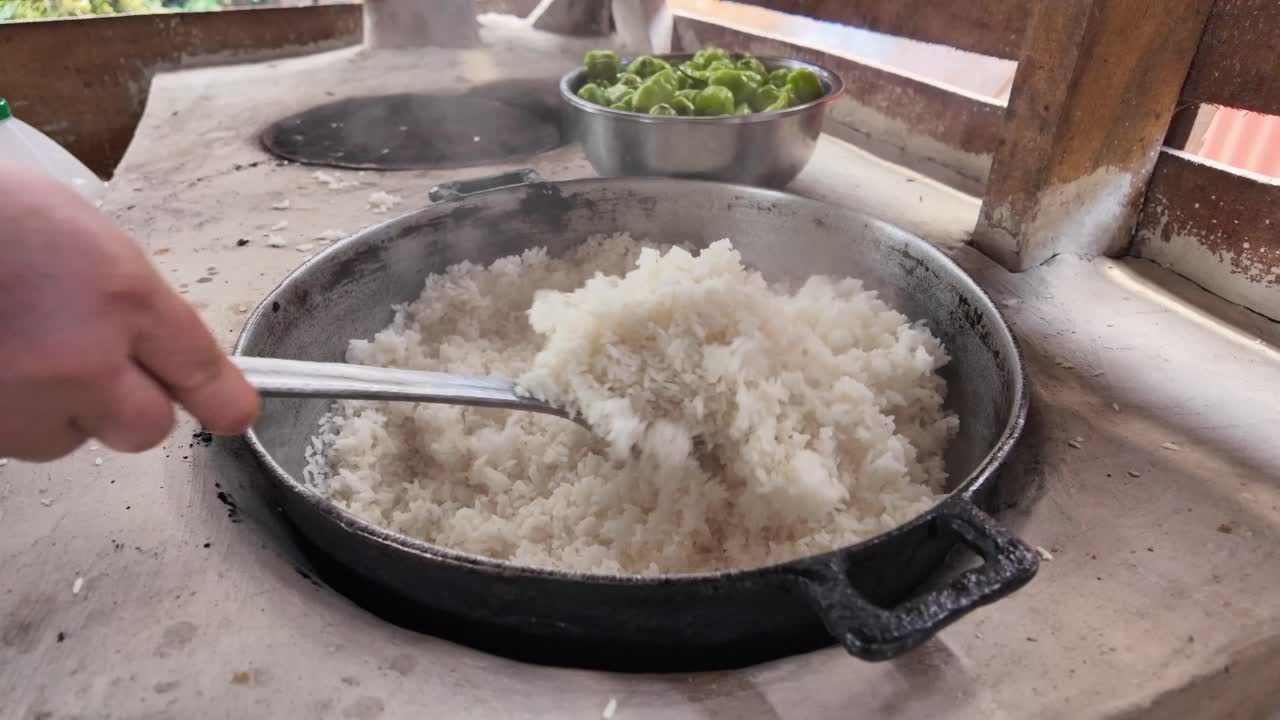Preparation of white rice in rural area, ladle stirring creole food, Dominican Republic, Close-up