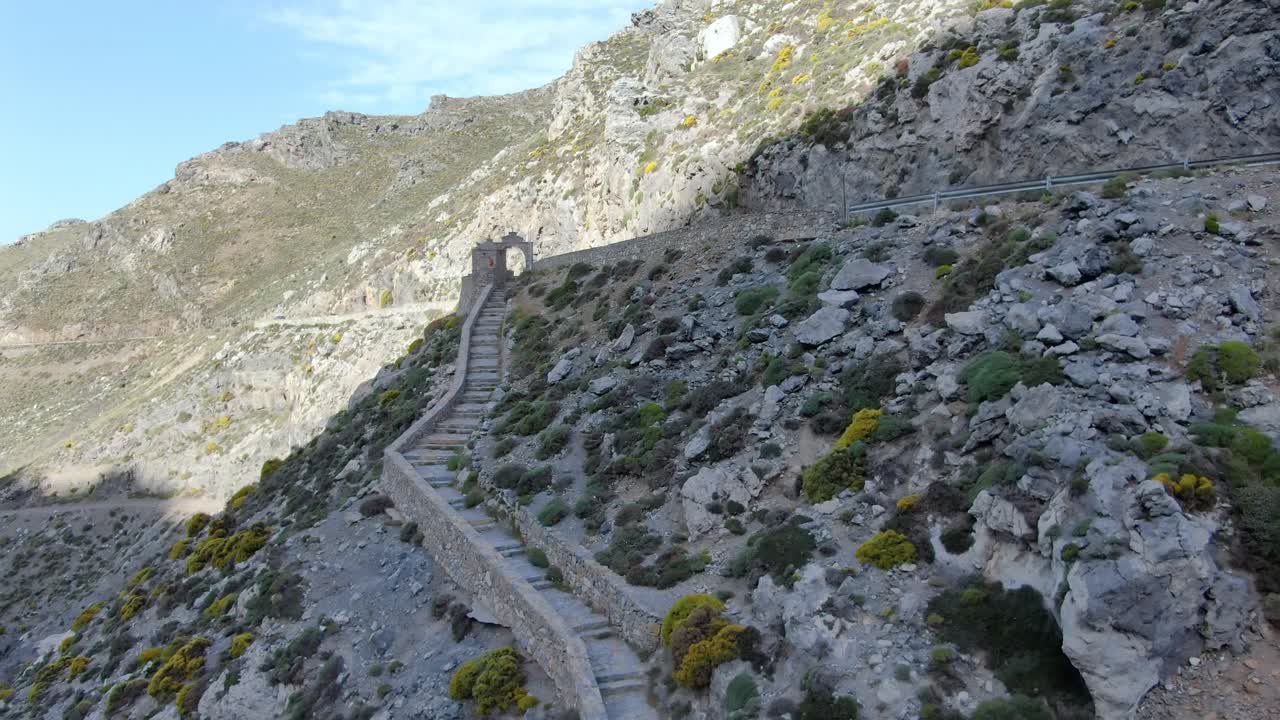 Aerial approaching view of cement steps along mountainside on sunny day