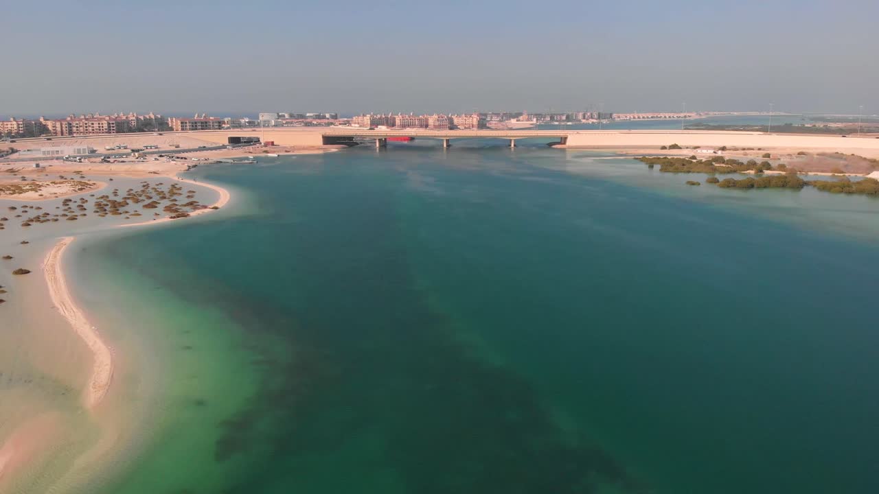 Drone Pullback Spectacular Turquoise River Waters with Cars Crossing over Bridge in Abu Dhabi