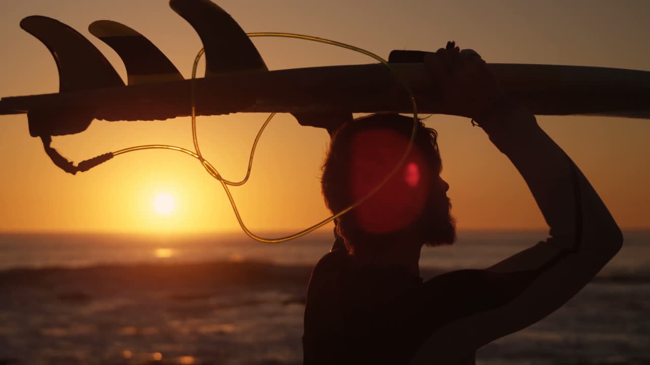 Uomo con tavola da surf in spiaggia 4k