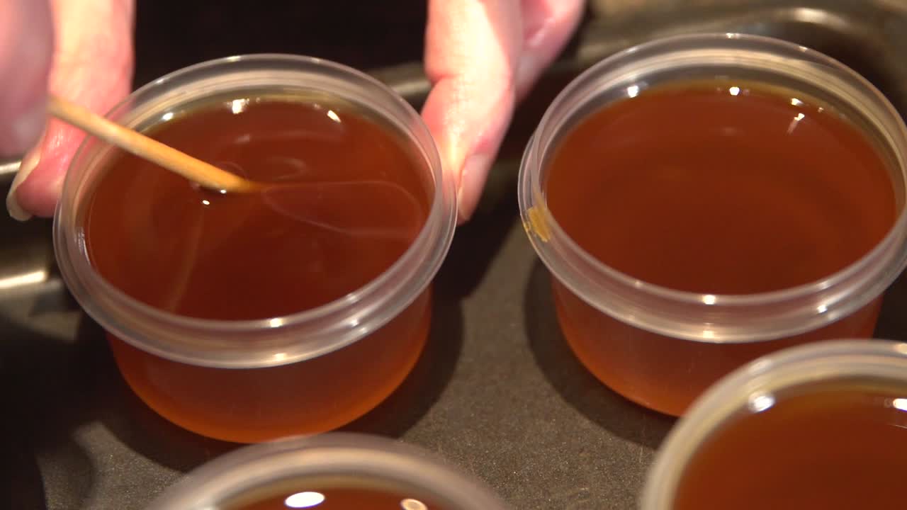 Olio fatto in casa denso e appena preparato, che viene mescolato e conservato in piccoli contenitori.