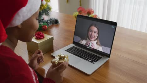 African-american-woman-with-santa-hat-using-laptop-for-christmas-video-call-with-woman-on-screen