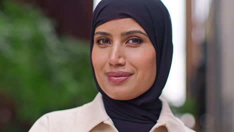 portrait of modern muslim businesswoman wearing hijab with business suit going to work standing outside office building with folded arms 2