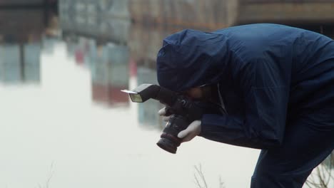 Forensic-detective-taking-photos-of-dead-person,-crime-scene-closeup-in-harbor