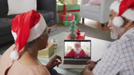 Happy-african-american-senior-couple-on-video-call-with-santa-claus-at-christmas