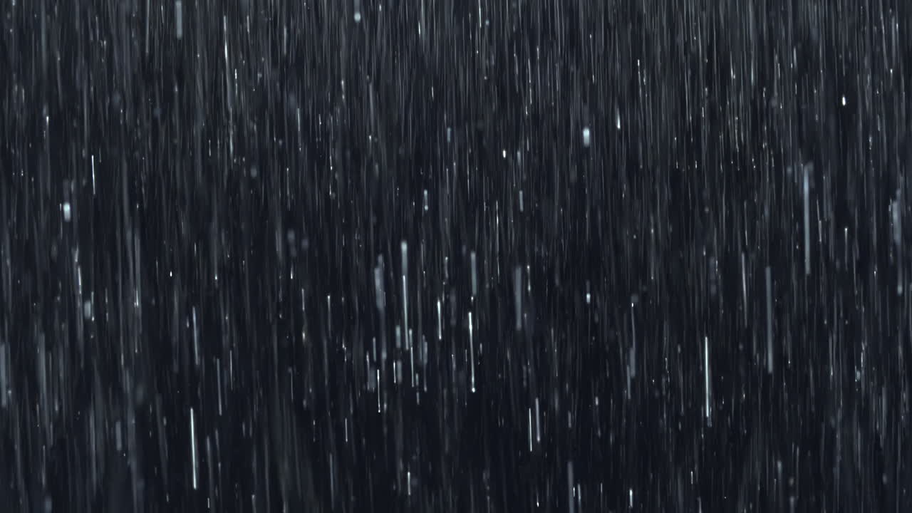Intense wall of rain falling against black. Featuring close-up raindrops splashing on impact. Practical, seamless, loopable VFX element ideal for storm scenes, dramatic moments, atmospheric overlays