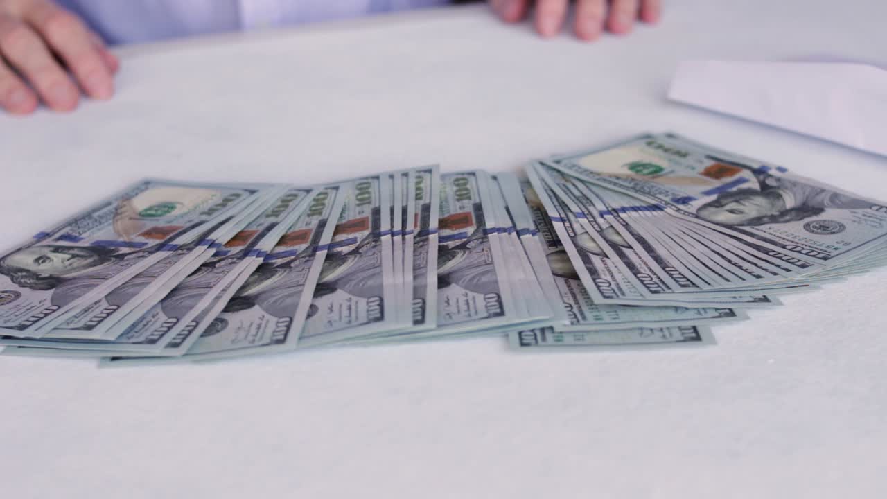 pila de nuevos billetes de cien dólares estadounidenses de sobre blanco