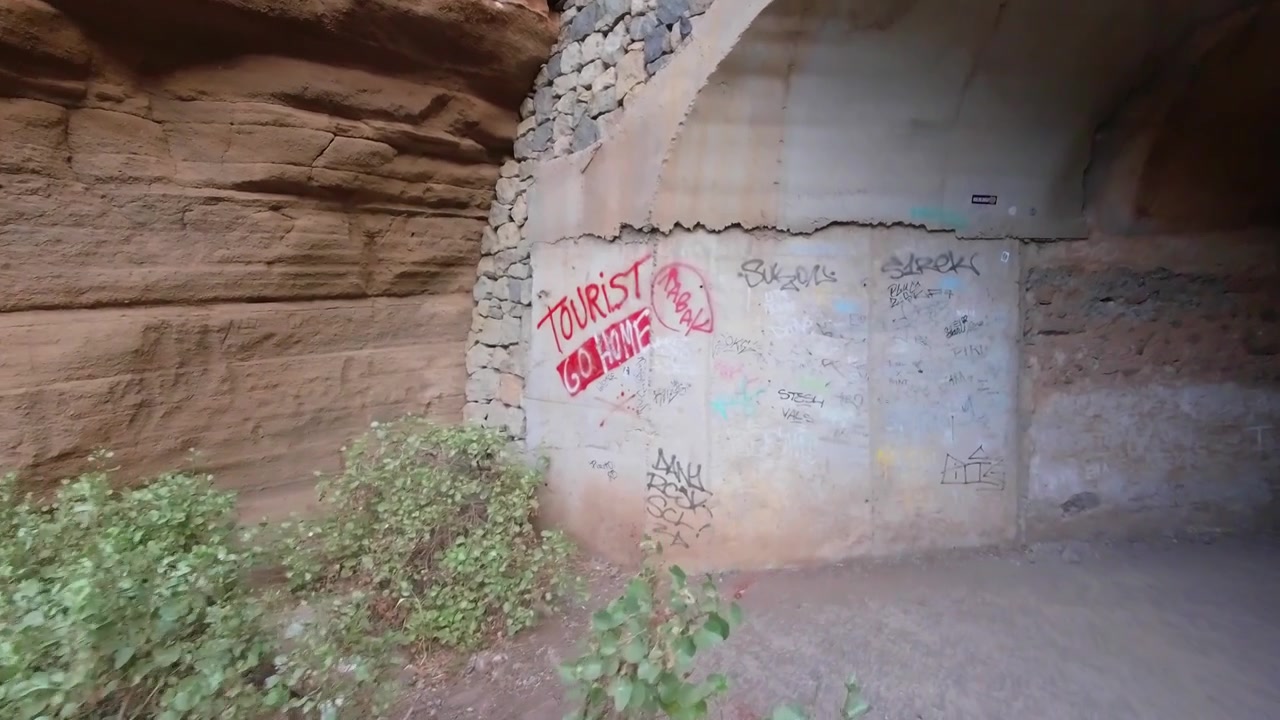 Gran Canaria'daki Barranco de las Vaces'e giden tünelin girişinde "Turistler evinize dönün" grafitisi.