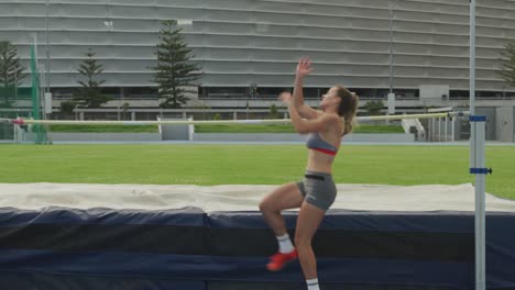 Caucasian-athlete-doing-high-jump