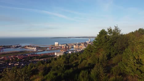 aerial reveal of marina and buildings from surrounding hills at sunrise