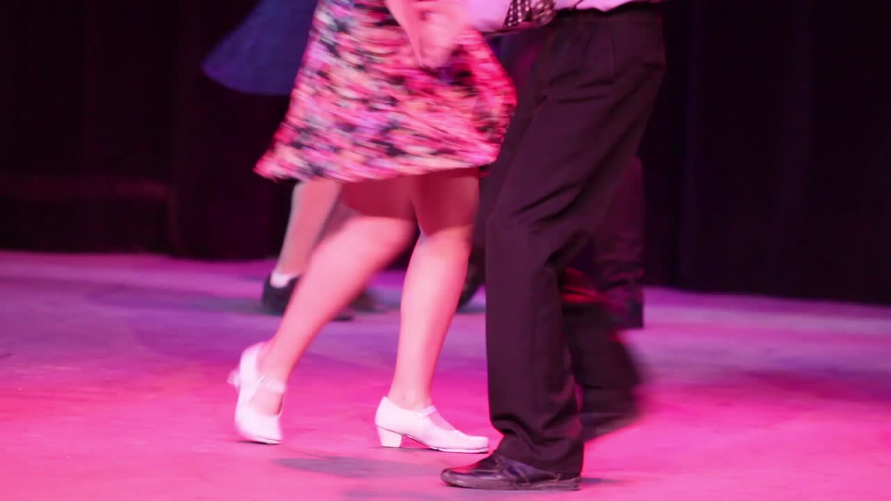 Close up to dancers feet dancing rock and roll, head silhouettes