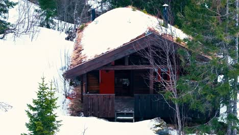 log cabin with roof covered in snow on mountain in verran, norway