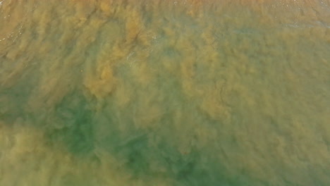 waves come and go from the candy beach. aerial perspective on the tide of the pacific ocean.