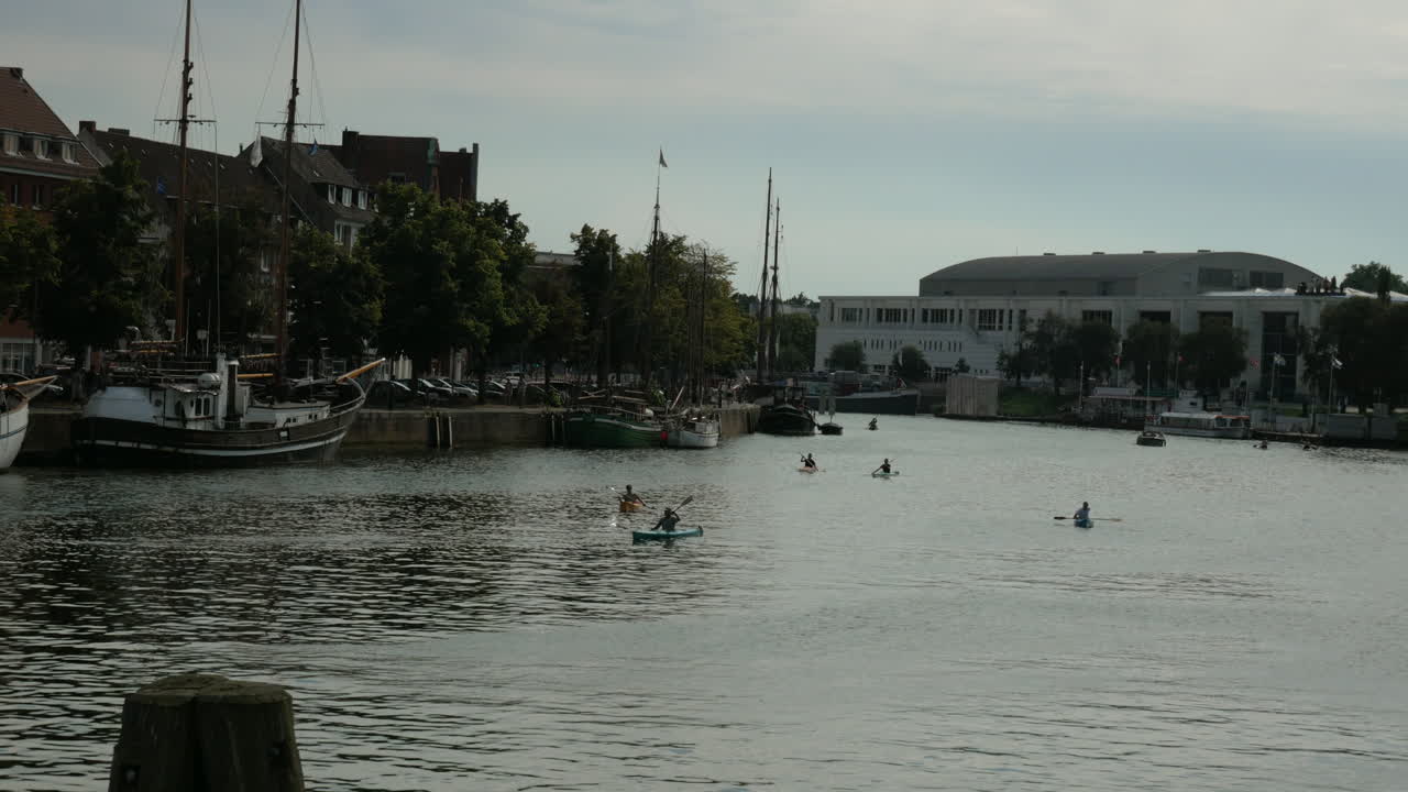 plano general que muestra a un grupo de personas remando en kayak en el río trave en lübeck durante la puesta de sol