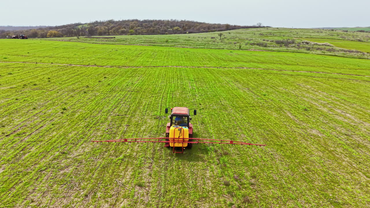 Gli agricoltori preparano il campo con il trattore per la semina su terreno verde durante il giorno.